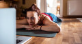 relaxing on a yoga mat while checking laptop 767x418